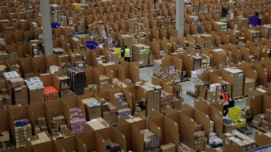 epa06355787 Workers at the Amazon logistics and distribution center in Rheinberg, Germany, 28 November 2017. The Amazon logistics center is directly connected to a &#039;Deutsche Post&#039; DHL shippi ...