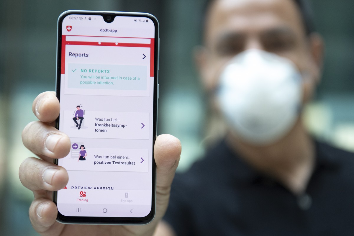 epa08381434 A person wearing protective face mask shows the smart phone app using Decentralized Privacy-Preserving Proximity Tracing (DP-3T) during a test with Swiss soldiers at the Swiss Federal Inst ...