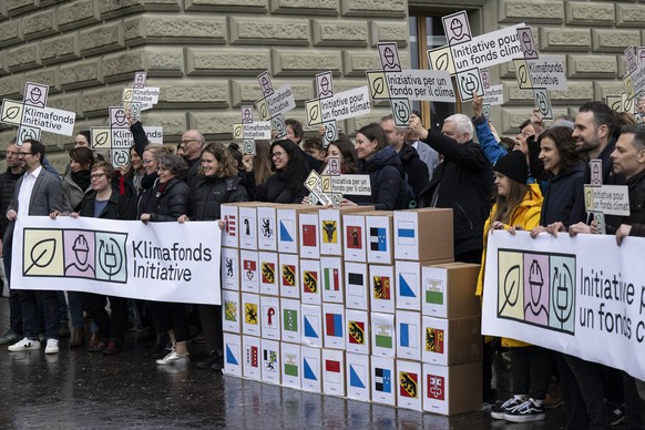 Personen der Gruene Schweiz und der SP Schweiz reichen die Klimafonds Initiative mit ueber 100 000 Unterschriften ein, am Donnerstag, 22. Februar 2024, in Bern. (KEYSTONE/Peter Schneider)