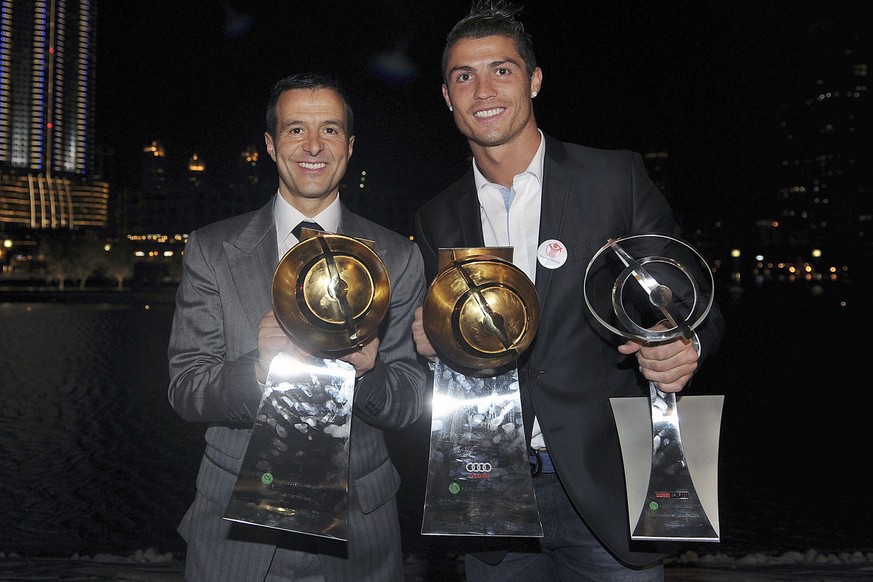 epa03044492 Real Madrid soccer player, Portuguese Cristiano Ronaldo (R), and his manager Jorge Mendes (L), pose with the trophies won during the Globe Soccer Awards ceremony held at Dubai, UAE, 28 Dec ...