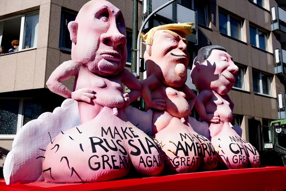 epa11937640 A carnival float by artist Jacques Tilly depicting (L-R) Russian President Vladimir Putin, U.S. President Donald Trump, and Chinese President Xi Jinping during the Rose Monday carnival par ...