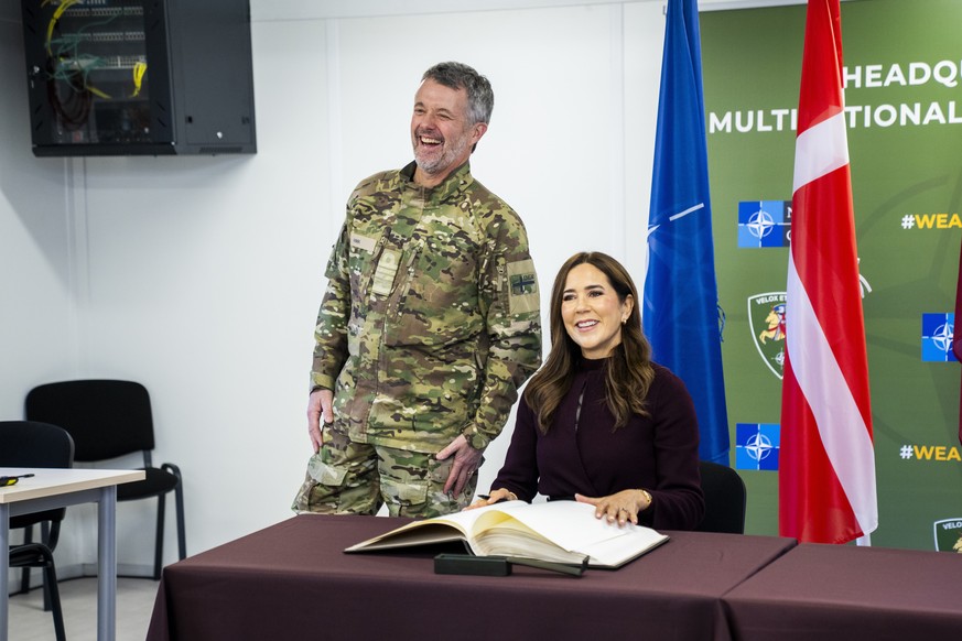 epa12491645 King Frederik (L) and Queen Mary (R) of Denmark sign the guestbook during a visit to Adazi Military Base in Adazi, Latvia, on 29 October 2025. During the visit, the royal couple inspected  ...