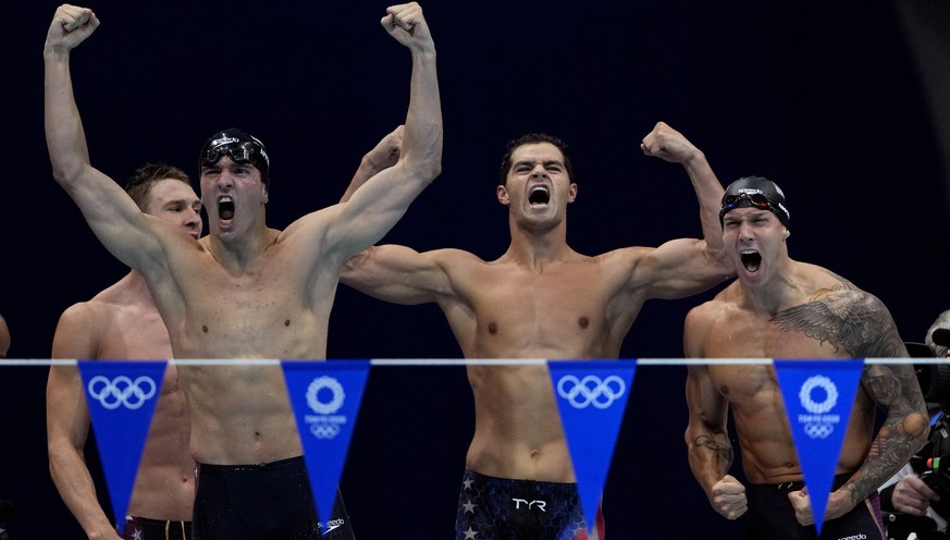 The United States&#039; men&#039;s 4x100-meter medley relay team, from left, Ryan Murphy, Zach Apple, Michael Andrew and Caeleb Dressel, celebrate winning the gold medal at the 2020 Summer Olympics, S ...