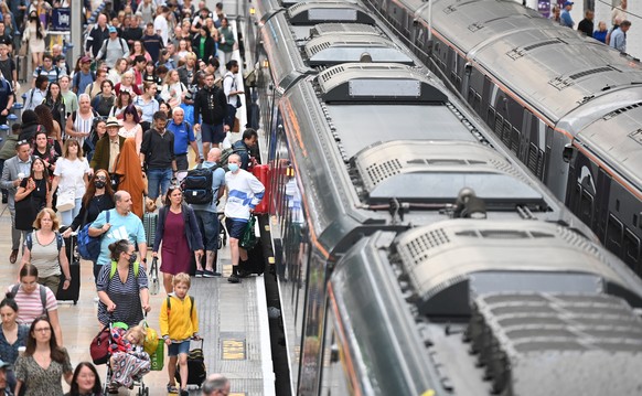 epa10092135 Travellers board a Great Western train at Paddington Station in London, Britain, 26 July 2022. The Rail Maritime and Transport Workers union (RMT) has organised 24-hour strikes for 27 and  ...