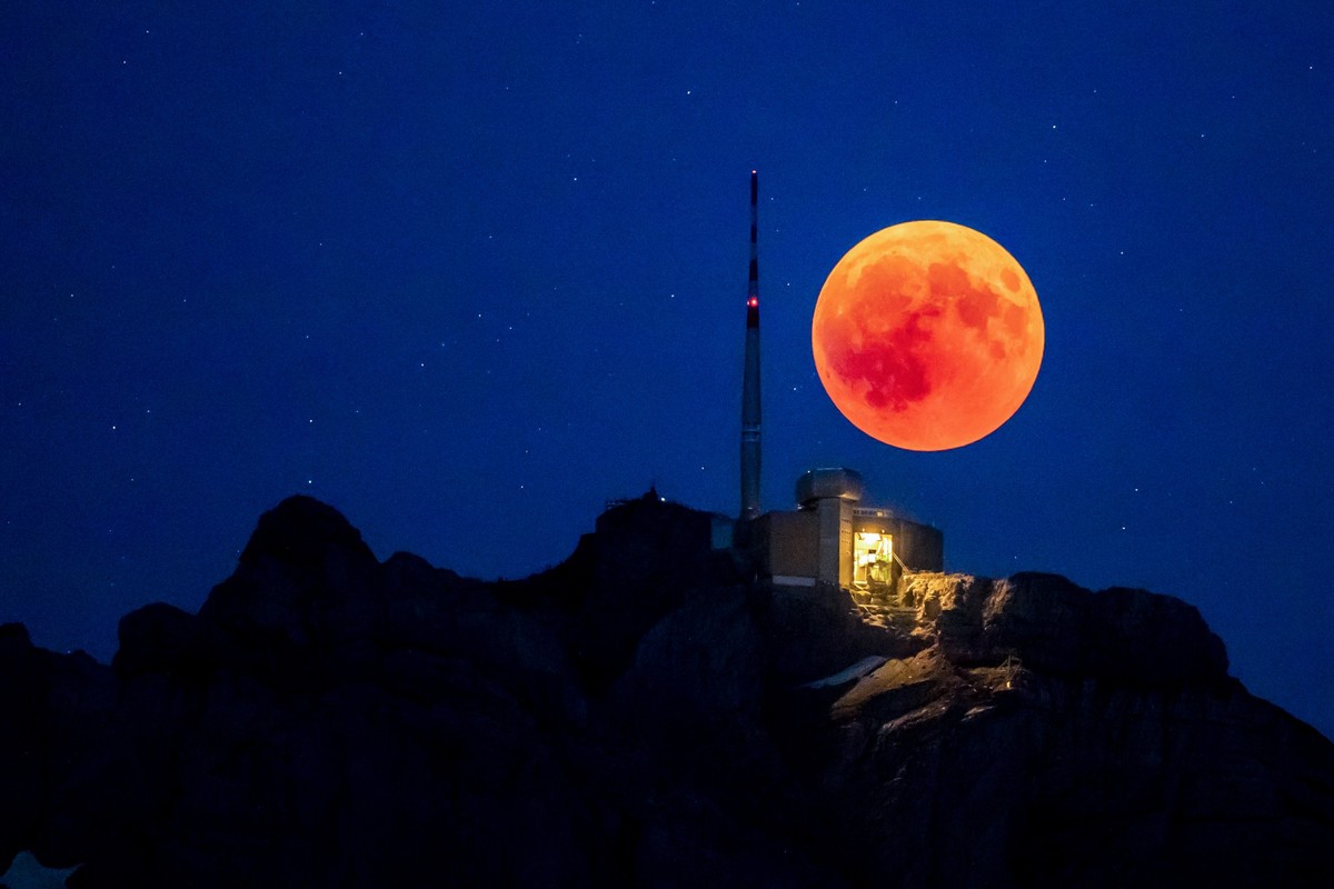 The blood moon rises behind the Saentis (2502m, Alpstein, Canton of Appenzell) on the night of the longest total lunar eclipse of the 21st century. (KEYSTONE/Christian Merz)