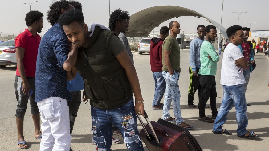 epa06585021 An Eritrean immigrant who has been released from the Holot detention facility (rear) near Nitzana in the Negev Desert in Israel, hugs a friend as they say goodbye, 06 March 2018. The Afric ...