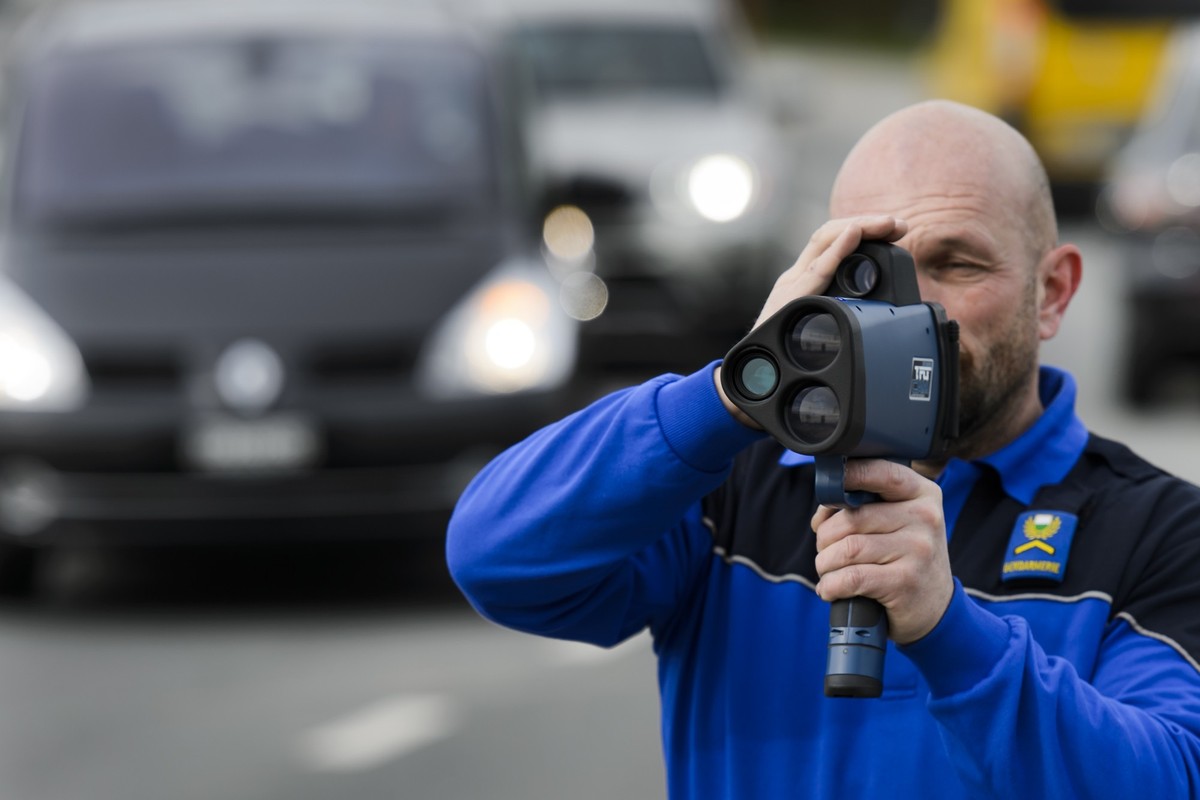 Un policier de la police cantonale vaudoise controle la vitesse d'une vehicule a l'aide d'un radar jumelle sur une route, mercredi 9 mars 2016, a Commugny dans le canton de Vaud. Comme  ...