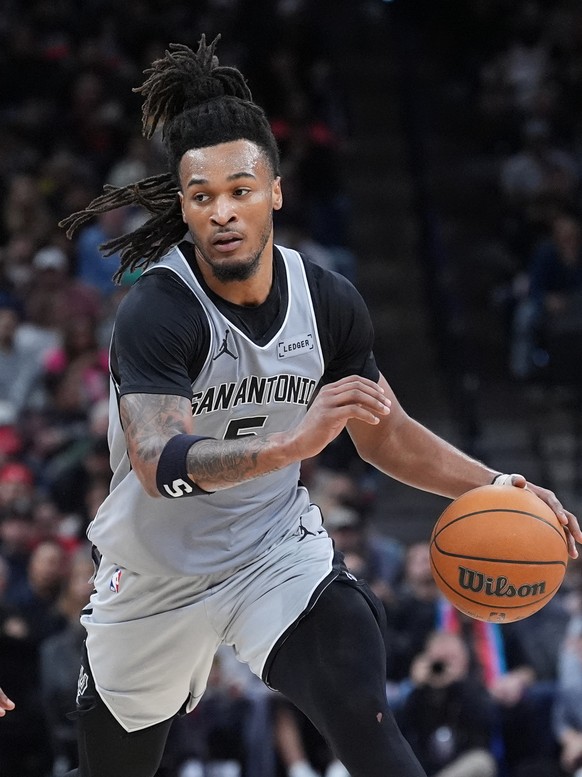 San Antonio Spurs guard Stephon Castle (5) drives around Houston Rockets forward Tari Eason (17) during the first half of an NBA basketball game in San Antonio, Sunday, March 8, 2026. (AP Photo/Eric G ...