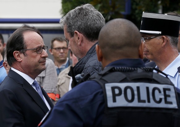 French President Francois Hollande (L) speaks with police forces after two assailants had taken five people hostage in the church at Saint-Etienne-du -Rouvray near Rouen in Normandy, France, July 26,  ...