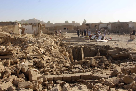 epa12457599 People stand amid rubble inside a home destroyed by cross-border shelling between Pakistan and Afghanistan in Spin Boldak, Afghanistan, 16 October 2025. Pakistan and Afghanistan?s Taliban  ...