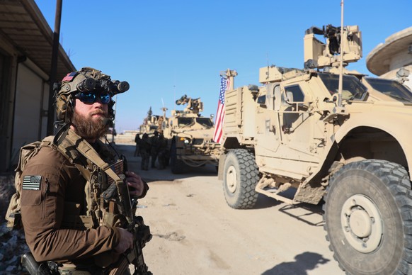 An American soldiers from the U.S.-led coalition against the Islamic State group stands guard during a meeting with the U.S.-backed Syrian Democratic Forces in Deir Hafer, Syria, Friday, Jan. 16, 2026 ...