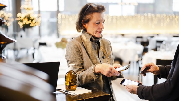 Restaurant Inhaberin Claudine Brunner kontrolliert ein Covid-Zertifikat im Restaurant LaSalle wo die 2G-Regel gilt und nur Gaeste die gegen das Coronavirus Covid-19 geimpft oder genesen sind Zutritt h ...