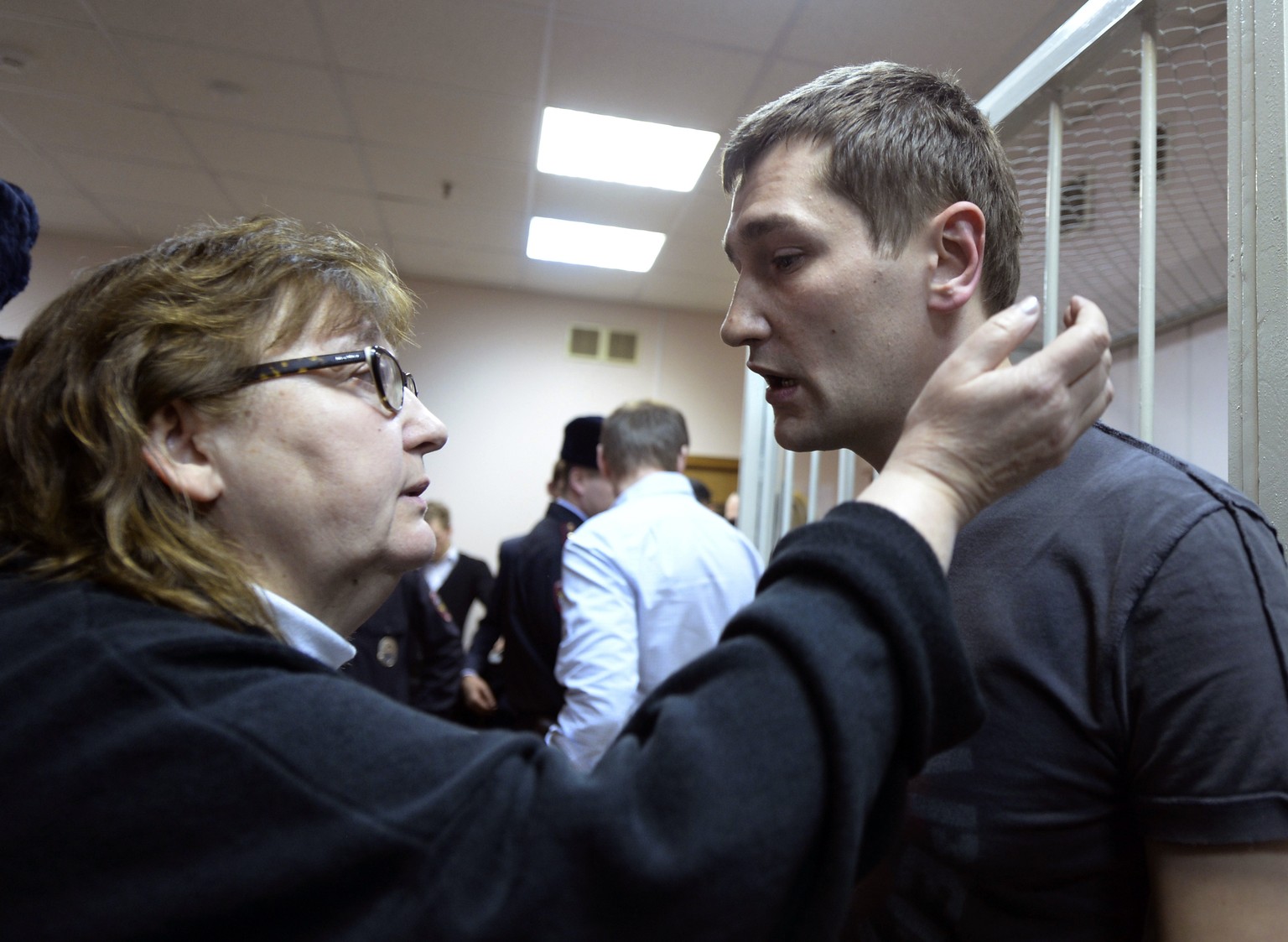 FILE - Russian opposition activist and anti-corruption crusader Alexei Navalny's brother, Oleg Navalny, speaks with his mother Lyudmila, left, in a court in Moscow, Russia, on Tuesday, December 1.  30, 2014. Al...