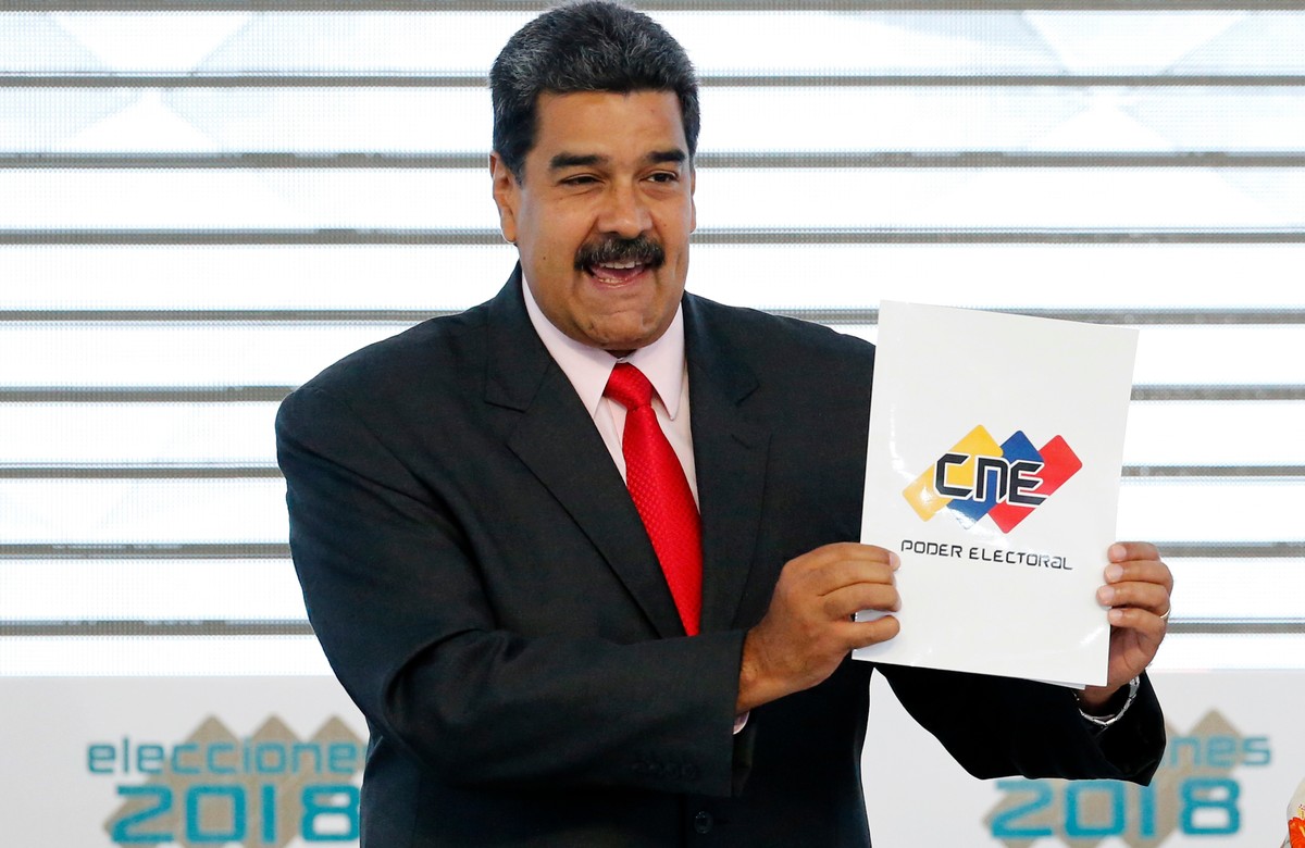 FILE - Venezuela's President Nicolas Maduro holds up the National Electoral Council certificate declaring him the winner of the presidential election, during a ceremony at CNE headquarters in Car ...