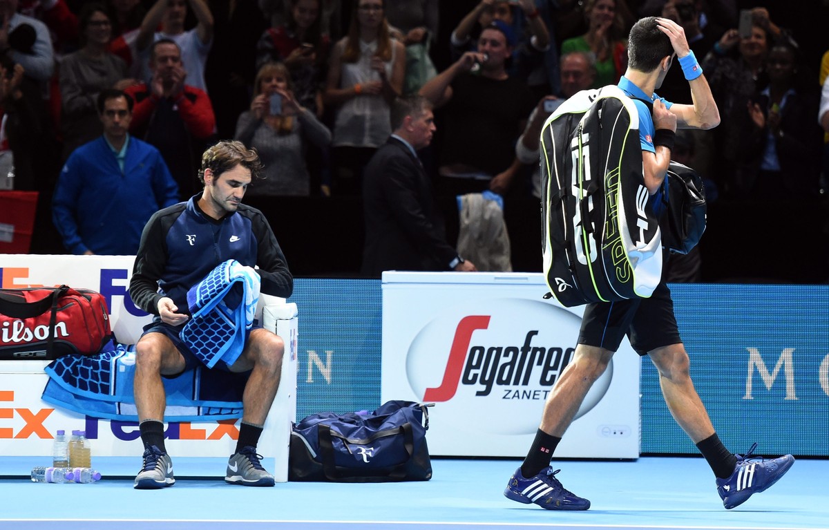 epa05030303 Serbia's Novak Djokovic (right) walks off the court after being defeated by Switzerland's Roger Federer (left) in their round robin game during the ATP World Tour Finals in Londo ...
