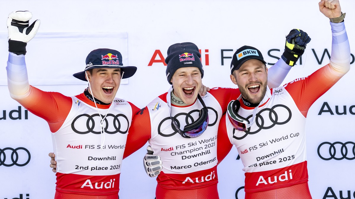 epaselect epa11982140 Marco Odermatt of Switzerland, center, celebrates with the men's Downhill discipline leader crystal globe trophy with second placed Franjo von Allmen of Switzerland, left, a ...