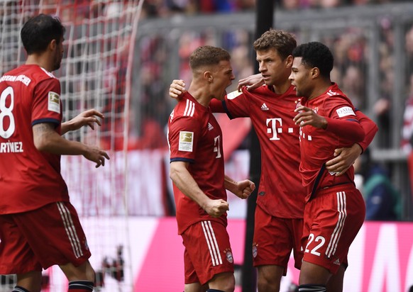 epa07424776 Bayern&#039;s Joshua Kimmich (L-R), Bayern&#039;s Thomas Mueller and Bayern&#039;s Serge Gnabry celebrate during the German Bundesliga soccer match between Bayern Munich and VfL Wolfsburg  ...