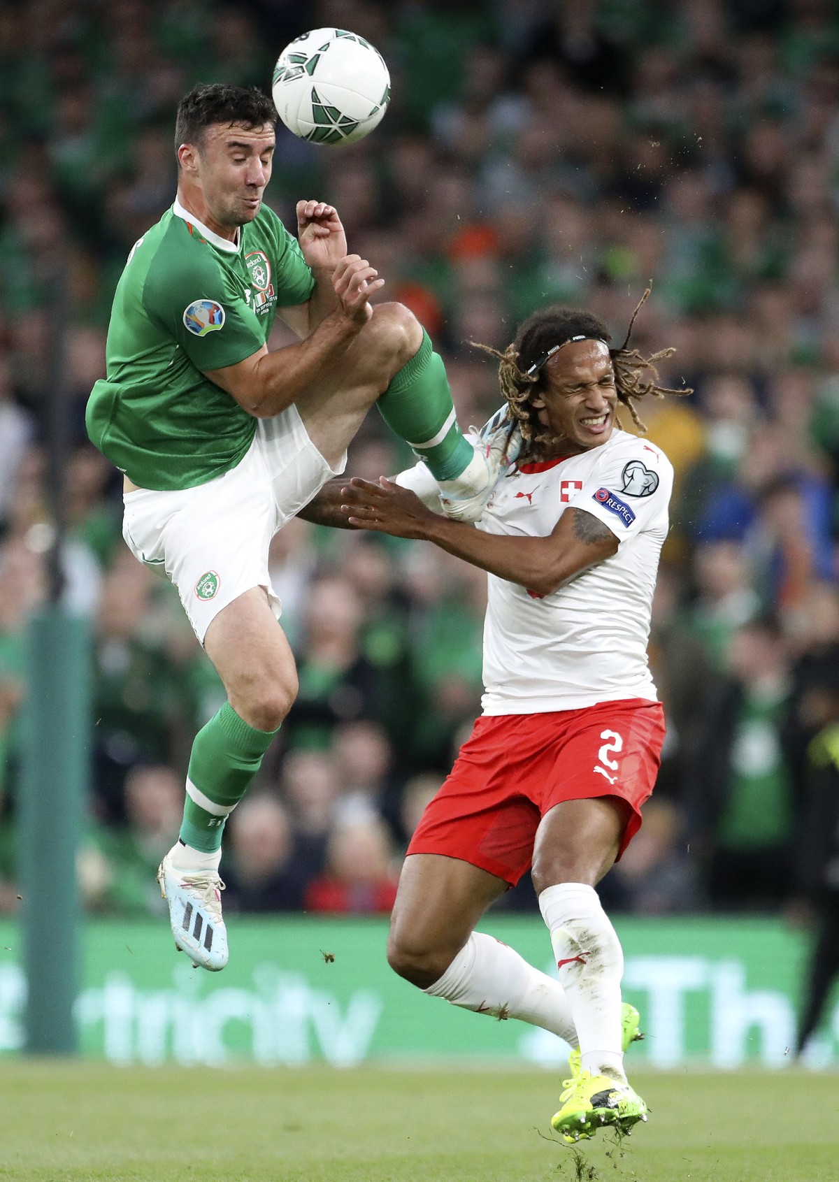 Ireland's Enda Stevens jumps for the ball and fouls Switzerland's Kevin Mbabu, right, during the Euro 2020 group D qualifying soccer match between Ireland and Switzerland at the Aviva stadiu ...