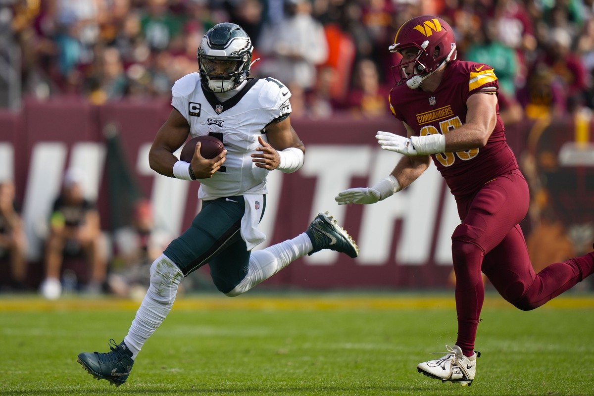 Philadelphia Eagles quarterback Jalen Hurts (1) is chased out of bounds by Washington Commanders defensive end Casey Toohill (95) during the second half of an NFL football game, Sunday, Oct. 29, 2023, ...