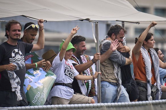 Swedish climate activist Greta Thunberg waves from a boat taking part in a civilian flotilla bound for Gaza, aiming to break the Israeli blockade and deliver humanitarian aid, in Barcelona, Spain, Sun ...