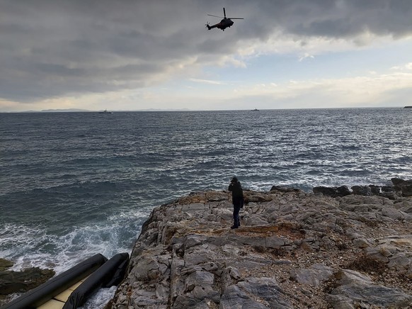 In this photo provided by the Greek Coast Guard, a helicopter searches over the Aegean Sea near the northwestern island of Lesbos, Greece, Tuesday, Feb. 7, 2023. Three migrants died and 16 were rescue ...