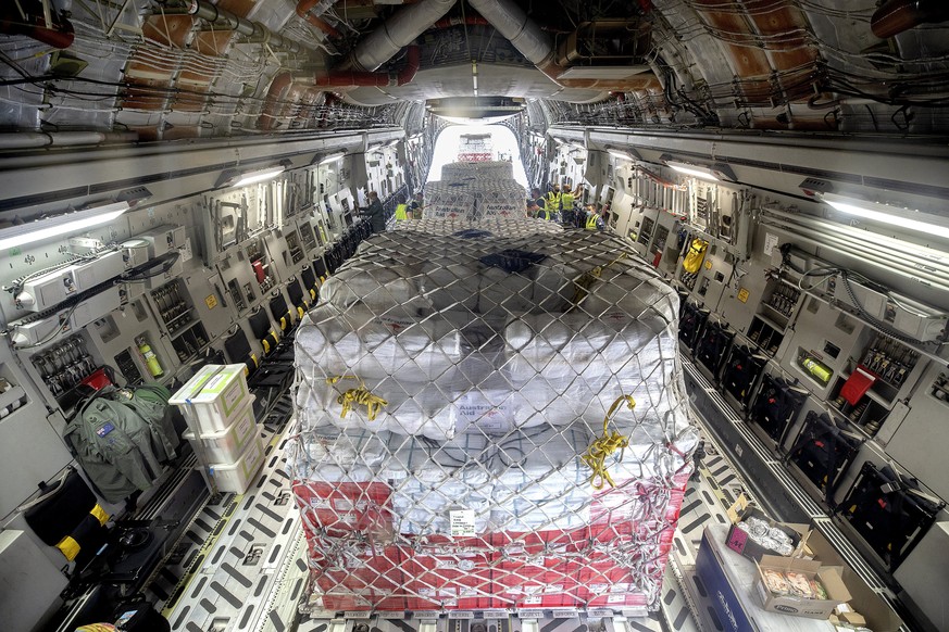 In this photo provided by the Australian Defence Force, pallets of aid bound for Tonga are secured on a Royal Australian Air Force C-17A Globemaster III aircraft at an airbase at Amberley, Australia,  ...