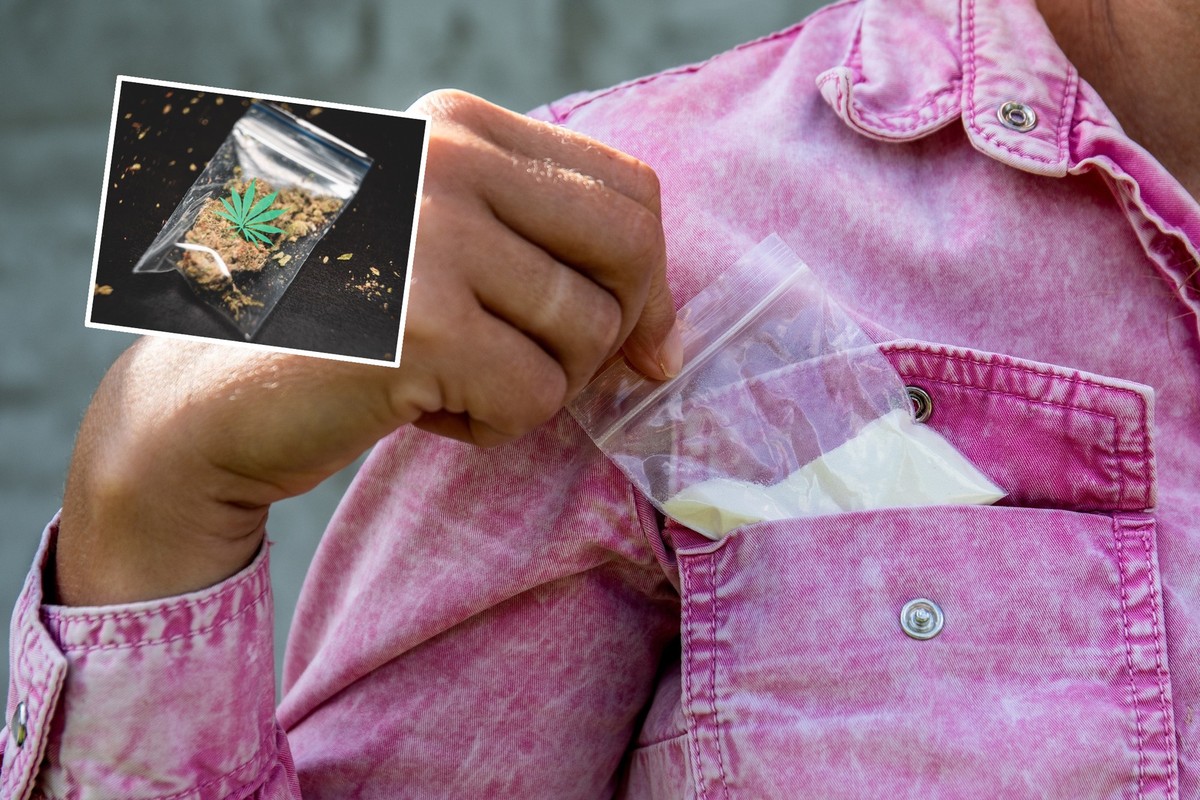 A bag of white powder taking out of pocket. Addiction and illegal trade concep. A woman's hand.