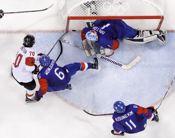 Denis Hollenstein (70), of Switzerland, scores a goal against goalie Matt Dalton (1), of South Korea, during the first period of the preliminary round of the men&#039;s hockey game at the 2018 Winter  ...