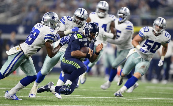 epa05006866 Seattle Seahawks quarterback Russell Wilson (C) runs the ball against the Dallas Cowboys in the second half of their game at AT&amp;T Stadium in Arlington, Texas, USA, 01 November 2015. EP ...