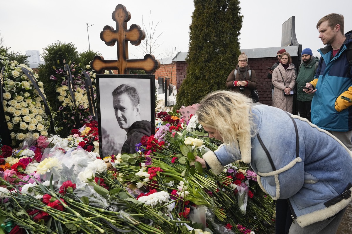 A woman lays flowers at the grave of Alexei Navalny a day after his funeral at the Borisovskoye Cemetery, in Moscow, Russia, on Saturday, March 2, 2024. Navalny, who was President Vladimir Putin' ...