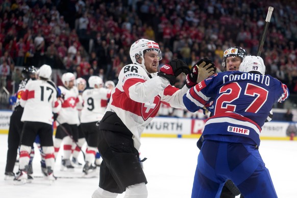 epa12961629 Switzerland's Janis Moser (L) and USA's Matt Coronato (R) scuffle after the 2026 IIHF Men's Ice Hockey World Championship preliminary round group A game between United State ...