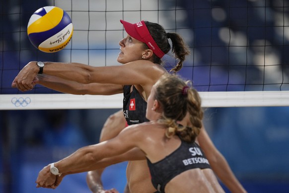 Tanja Huberli, top, of Switzerland, returns a shot as teammate Nina Betschart, helps out during a women&#039;s beach volleyball match against Switzerland at the 2020 Summer Olympics, Sunday, Aug. 1, 2 ...