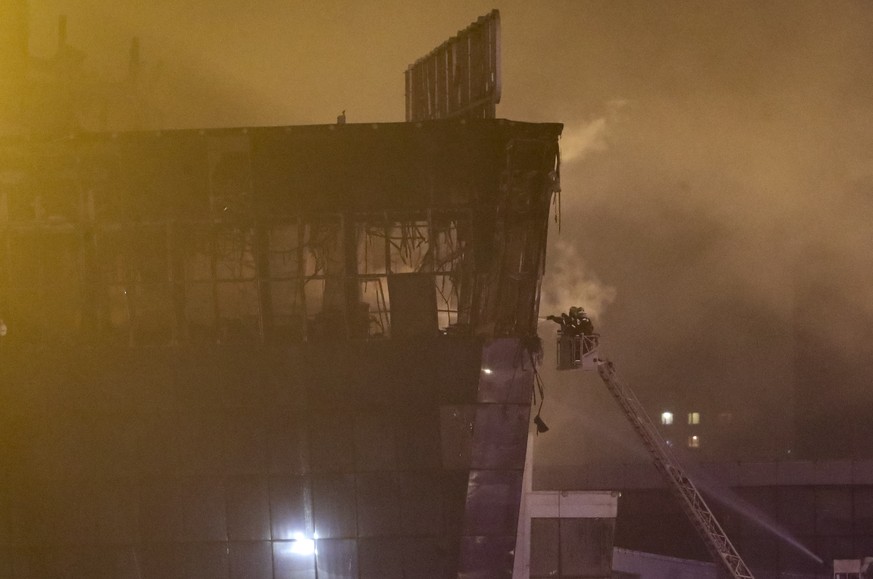 epa11237512 Firefighters try to extinguish a fire at the burning Crocus City Hall concert venue following a shooting in Krasnogorsk, outside Moscow, Russia, 22 March 2024. A group of up to five gunmen ...