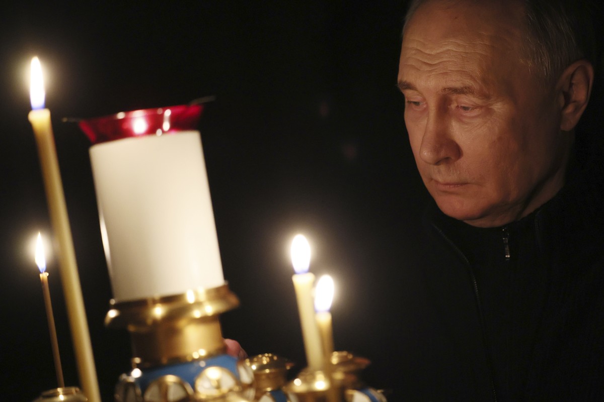 Russian President Vladimir Putin lights a candle to commemorate the victims of an attack on the Crocus City Hall concert venue, on the day of national mourning, in Russia, Sunday, March 24, 2024. (Mik ...