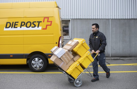 Paketzusteller der Schweizerischen Post Halid Dursun befoerdert Pakete auf einer Sackkarre fuer die Zustellung zum Kunden, aufgenommen am Montag, 15. November 2021 in Zuerich. (KEYSTONE / Ennio Leanza ...