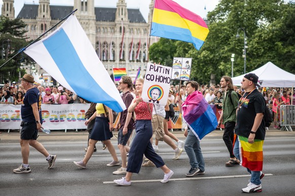 epa10696580 A woman displays a banner reading &#039;Putin go homo&#039; as she attend the Rainbow Parade in Vienna, Austria, 17 June 2023. The Rainbow Parade, a rally against the discrimination of les ...