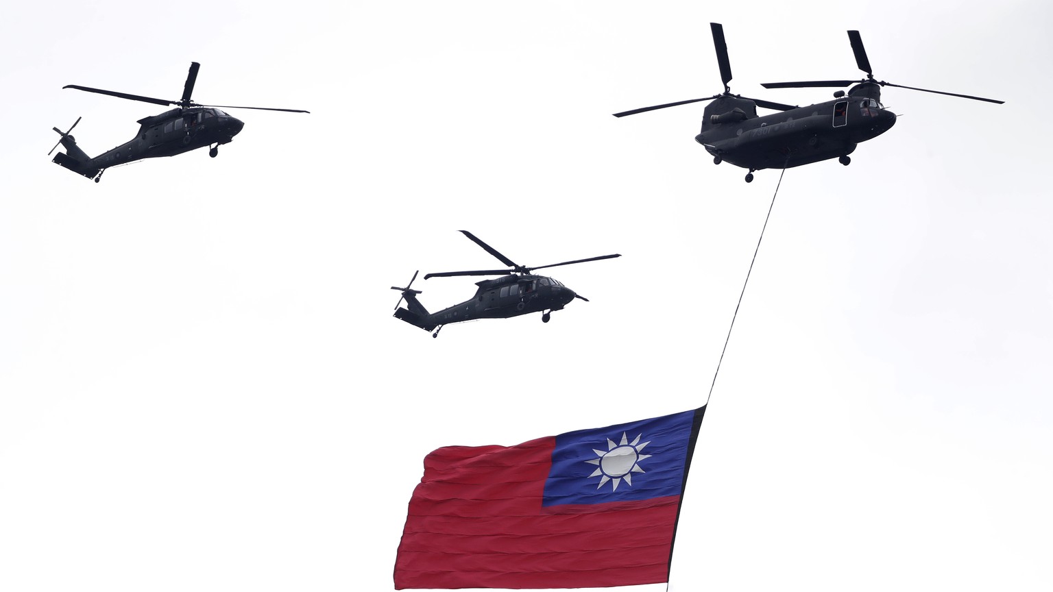 Helicopters fly over with Taiwan National flag during an inauguration celebration of Taiwan&#039;s President Lai Ching-te in Taipei, Taiwan, Monday, May 20, 2024. (AP Photo/Chiang Ying-ying)