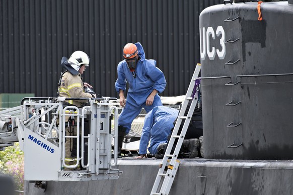 epa06141946 Danish police technicians investigating the recovered privately owned submarine Nautilus UC3 in Copenhagen Habor, Denmark, 13 August 2013. Swedish journalist Kim Wall who was on board the  ...