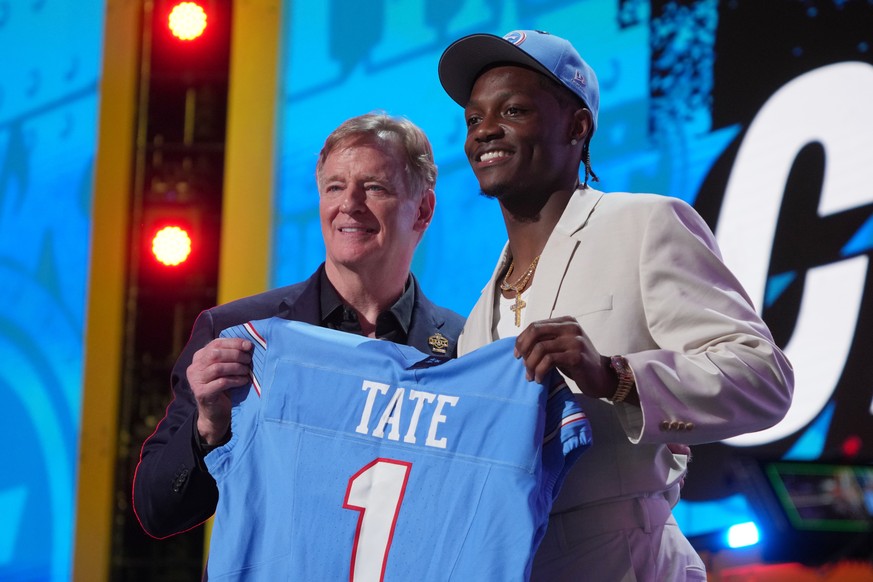 Ohio State wide receiver Carnell Tate poses with NFL Commissioner Roger Goodell after being chosen by the Tennessee Titans with the fourth overall pick during the first round of the NFL football draft ...