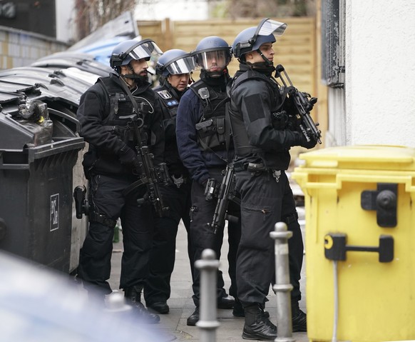 Armed police officers stand between buildings during a police operation near the former Checkpoint Charlie in Berlin, Germany, Monday, Dec. 30, 2019. Police say a person apparently fired several shots ...