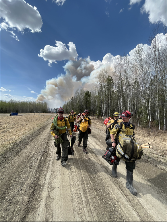 Feuerwehrmänner im Einsatz in Alberta, Kanada, um gegen ein Waldfeuer zu kämpfen