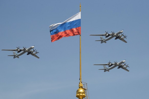 FILE - Russian Tu-95 strategic bombers fly past a Russian flag at the Kremlin complex during a rehearsal for the Victory Day military parade in Moscow, Russia, May 4, 2018. (AP Photo/Pavel Golovkin, F ...