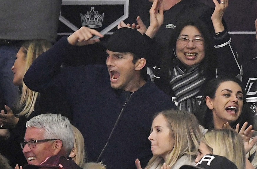 Actor Ashton Kutcher, left, and actress Mila Kunis celebrate a Los Angeles Kings goal during the third period of an NHL hockey game between the Kings and the Vegas Golden Knights, Monday, Feb. 26, 201 ...