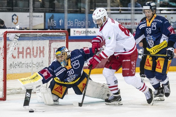 Zugs Torhueter Leonardo Genoni, Lausannes Cody Almond und Zugs Jesse Zgraggen, von links, beim Eishockey Meisterschaftsspiel der National League zwischen dem EV Zug und dem Lausanne HC, am Dienstag, 1 ...