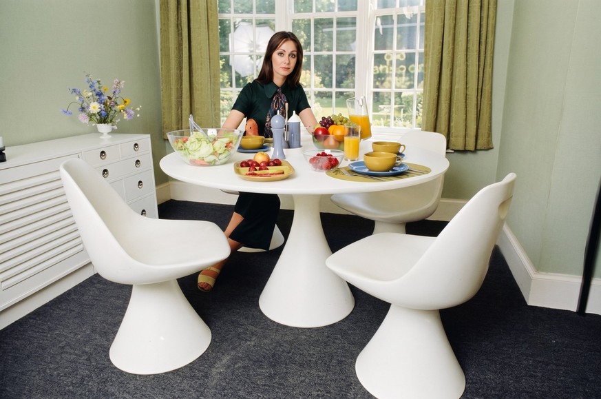 Modern Furniture 1969 A display of modern furniture, a woman sitting in a modern dining room space, 30th June 1969. (Photo by Goodway/Mirrorpix/Getty Images)