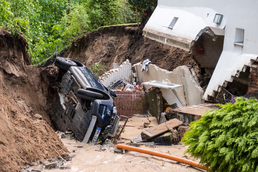 10.05.2018, Hamburg: Ein Auto liegt in Hamburg-Lohbruegge in einer Senke die nach heftigem Regen entstanden ist. Das anliegende Wohnhaus musste wegen der Unterspuelung evakuiert werden. (KEYSTONE/DPA/ ...