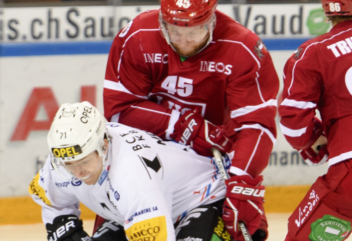 L'attaquant fribourgeois Killian Mottet, gauche, lutte pour le puck avec le defenseur lausannois Jonas Junland, droite, lors du match du championnat suisse de hockey sur glace de National League  ...