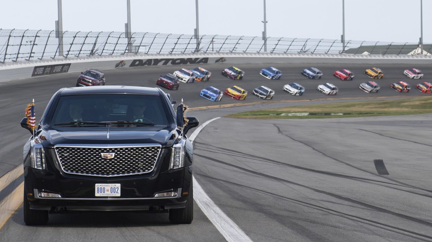 President Donald Trump and first lady Melania Trump ride in the presidential limousine as they take a pace lap ahead of the start of the NASCAR Daytona 500 auto race at Daytona International Speedway  ...