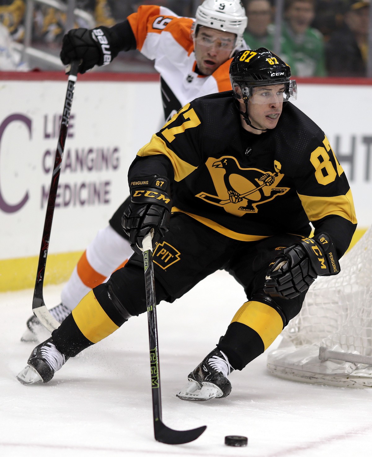 Pittsburgh Penguins' Sidney Crosby (87) wraps around the back of goal with Philadelphia Flyers' Ivan Provorov (9) defending during the second period of an NHL hockey game in Pittsburgh, Sund ...
