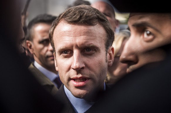 epa06907395 The then French presidential candidate Emmanuel Macron (C) of the &#039;En Marche&#039; political movement, flanked by security staff Alexandre Benalla (R), speaks with employees of the Wh ...